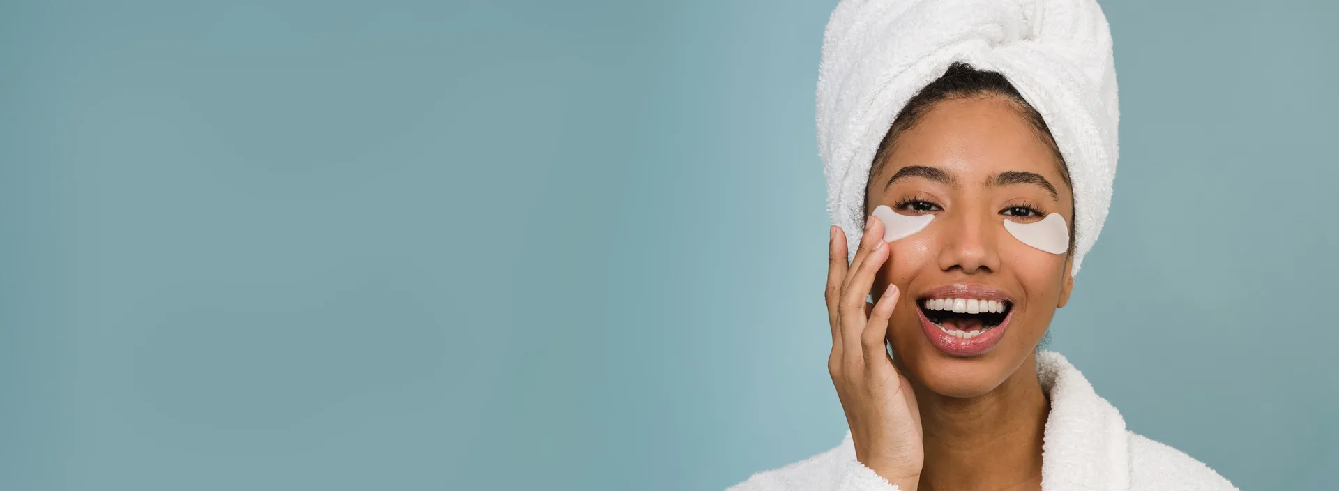 Woman with a towel on her head touches her face